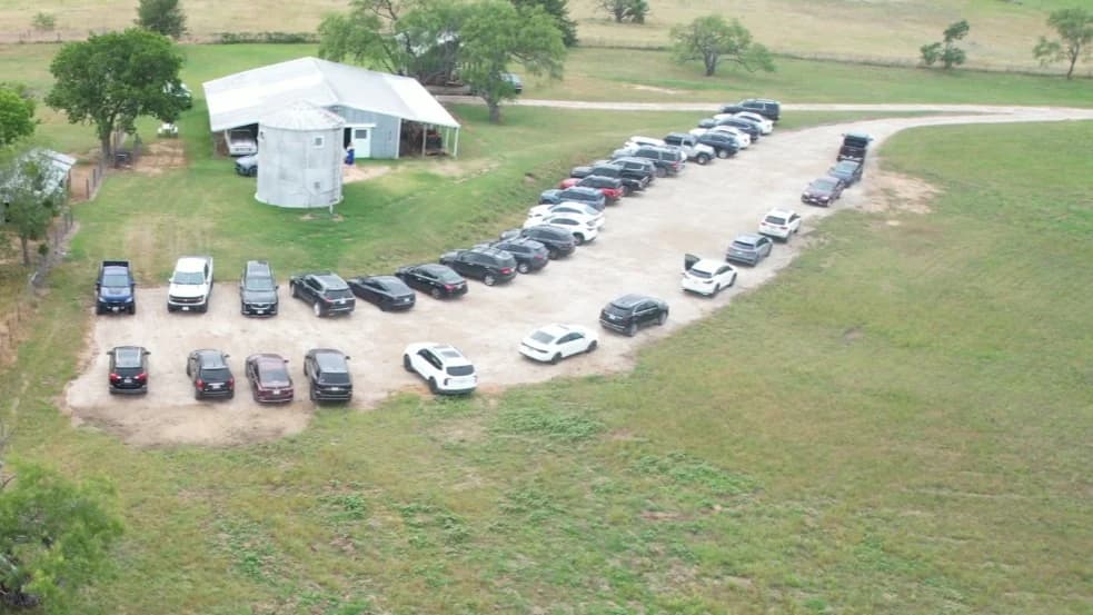 An aerial view of the gravel parking area beside the barn and grain-bin suite